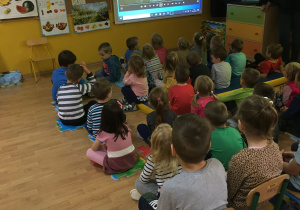 Na zdjęciu znajdują się dzieci oglądające film edukacyjny o drzewach