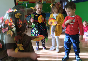 Na zdjęciu są dzieci zbierające jesienne liście