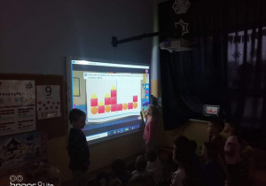 Na zdjęciu znajdują się dzieci układające puzzle na ekranie.
