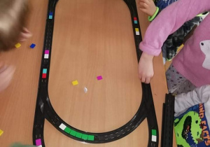 Na zdjęciu znajdują się dzieci kodujące tor jazdy pociągu.