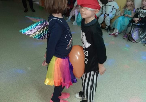 Para dzieci tańczące z balonem