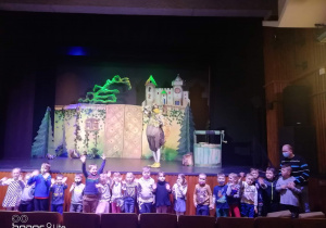 Na zdjęciu pod sceną teatru znajdują dzieci z grupy Kreciki wraz z tytułową Złotą Kaczką na scenie.