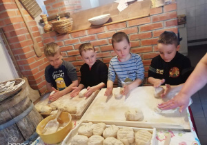 Na zdjęciu znajdują się dzieci robiące chlebki