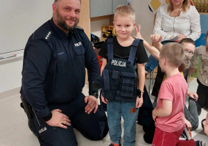 Pan policjant i chłopiec w kamizelce kuloodpornej