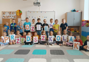 Grupa Misie trzymająca napis Dzień Pzredszkolaka
