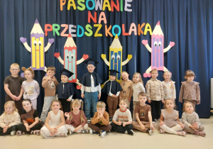 Grupa Motylki na tle napisu Pasowanie na Przedszkolaka