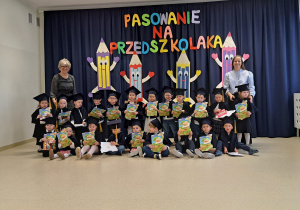 Grupa Sarenki na tle napisu Pasowanie na Przedszkolaka