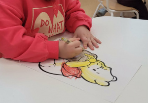 Dziewczynka kolorująca Kubusia Puchatka