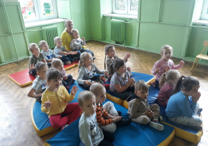 Na zdjęciu widać dzieci z grupy Motylków wsłuchujące się w dźwięki instrumentu