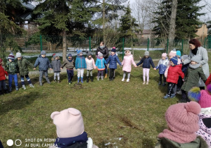 Dzieci stojące po okręgu z Marzanną w środku